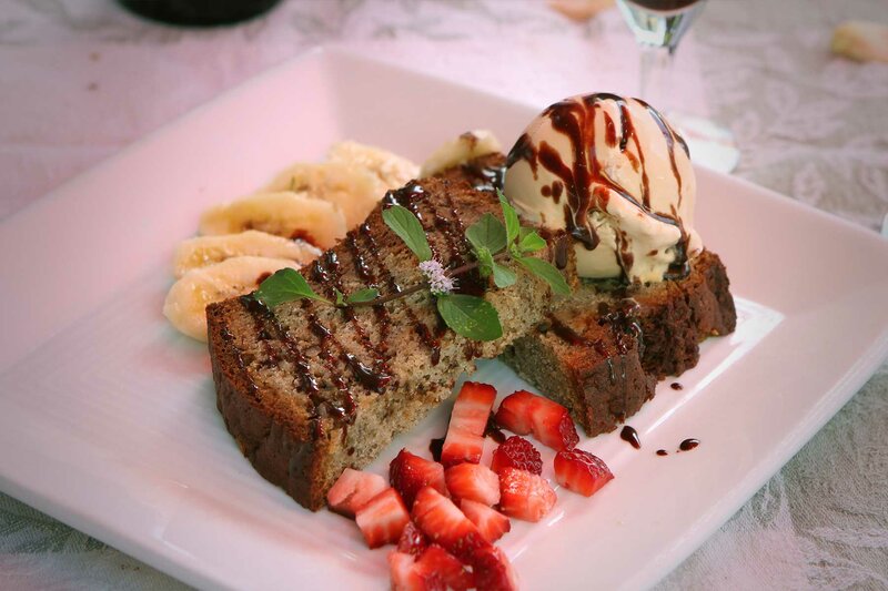 Cake topped with ice cream with strawberries and bananas